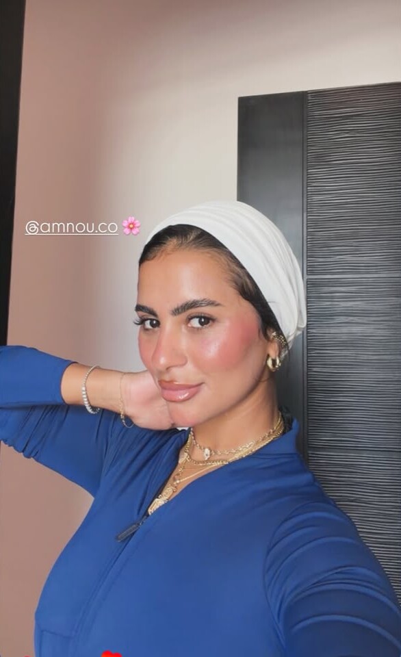 A woman in a cream turban and blue top